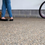 A woman and her bike on a stone and epoxy floor by Coastal Stone Flooring.